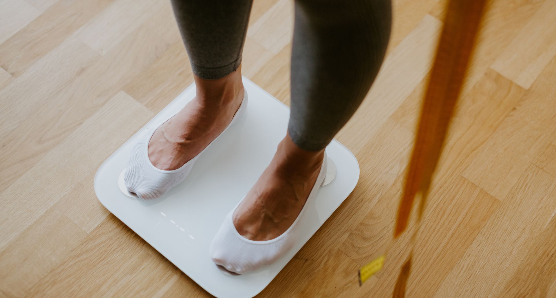 woman looking at the weight she lost
